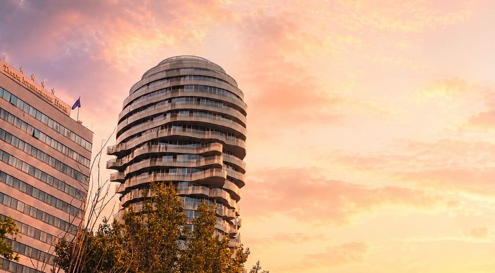 Modern round residential tower in Tirana at sunset