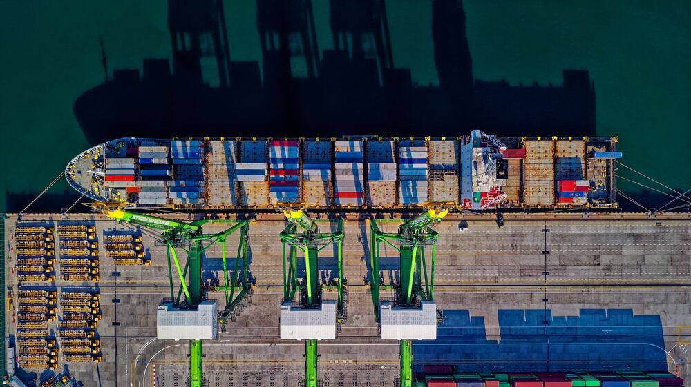 Pamje nga ajri e një anijeje kontejnerësh në një port të ngarkuar